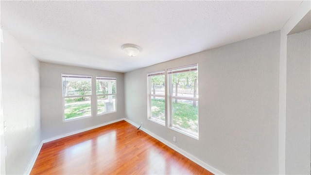 1230 W Mount Comfort Rd, Fayetteville, AR 72703 - empty room with baseboards, wood finished floors, and a textured ceiling