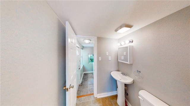 1230 W Mount Comfort Rd, Fayetteville, AR 72703 - bathroom with toilet, tile patterned flooring, a sink, baseboards, and a textured wall