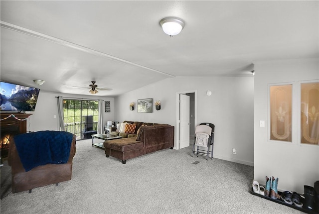 14650 Mariano Rd, Bentonville, AR 72712 - carpeted living area with vaulted ceiling, a warm lit fireplace, ceiling fan, and baseboards