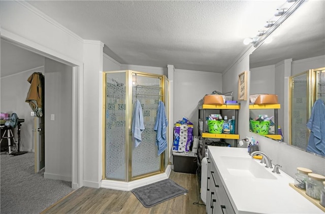 14650 Mariano Rd, Bentonville, AR 72712 - full bathroom featuring a shower stall, a textured ceiling, vanity, wood finished floors, and ornamental molding