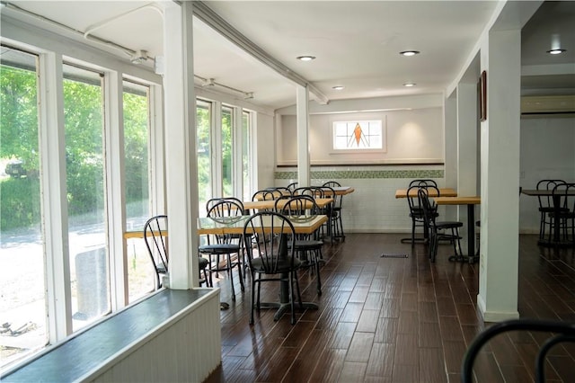dining area with plenty of natural light, dark wood-style flooring, and wainscoting