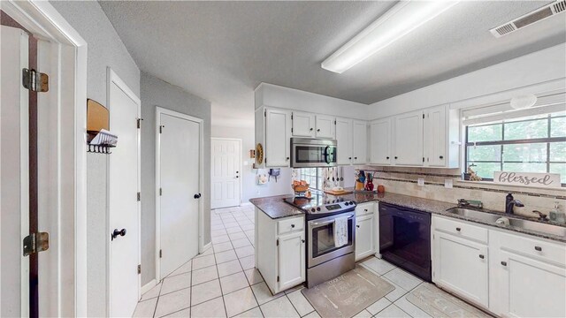 12526 Avoca Hollow Rd, Garfield, AR 72732 - kitchen featuring stainless steel appliances, a sink, light tile patterned floors, white cabinetry, and a textured ceiling