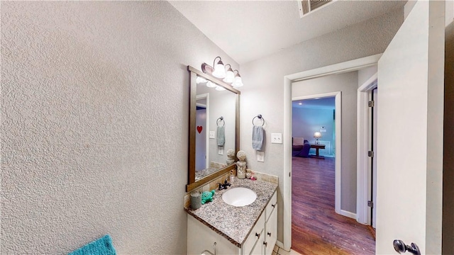 12526 Avoca Hollow Rd, Garfield, AR 72732 - bathroom with vanity, wood finished floors, and a textured wall