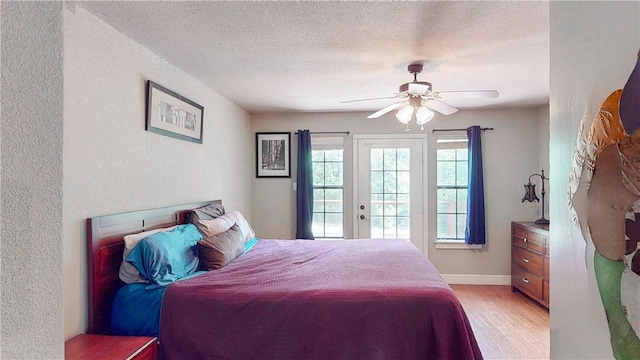 12526 Avoca Hollow Rd, Garfield, AR 72732 - bedroom with light wood-style flooring, a textured wall, access to exterior, a textured ceiling, and a ceiling fan