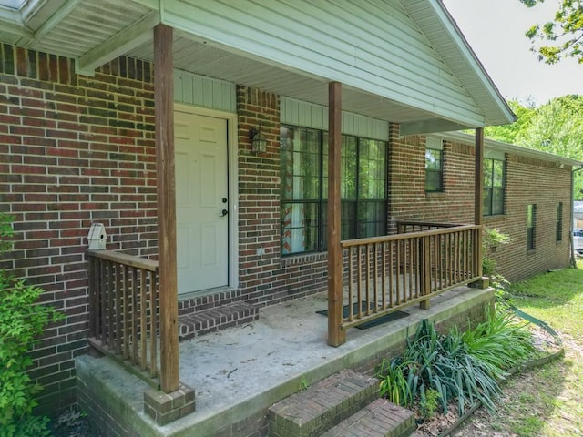 12526 Avoca Hollow Rd, Garfield, AR 72732 - doorway to property featuring covered porch and brick siding