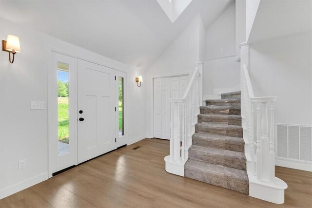 12391 Shamrock Rd, Farmington, AR 72730 - entryway with stairs, wood finished floors, high vaulted ceiling, and baseboards