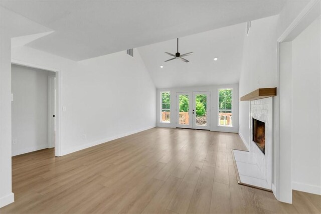 12391 Shamrock Rd, Farmington, AR 72730 - unfurnished living room featuring a tile fireplace, a ceiling fan, light wood-type flooring, lofted ceiling, and baseboards