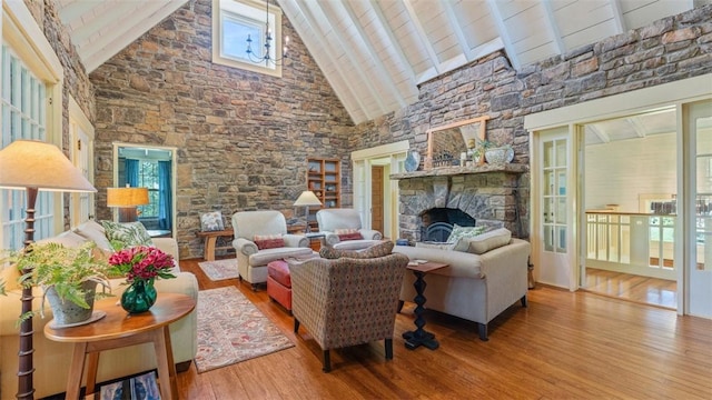 living room featuring a fireplace, high vaulted ceiling, wood finished floors, and beamed ceiling