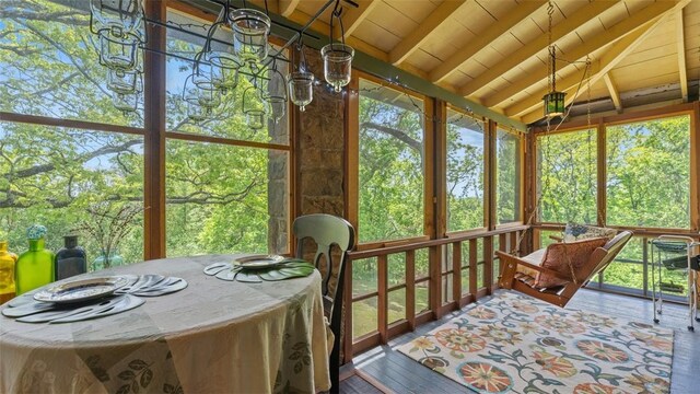 sunroom / solarium with healthy amount of natural light, wood finished floors, and wood ceiling