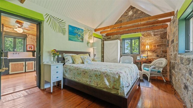 bedroom with lofted ceiling, multiple windows, and hardwood / wood-style flooring