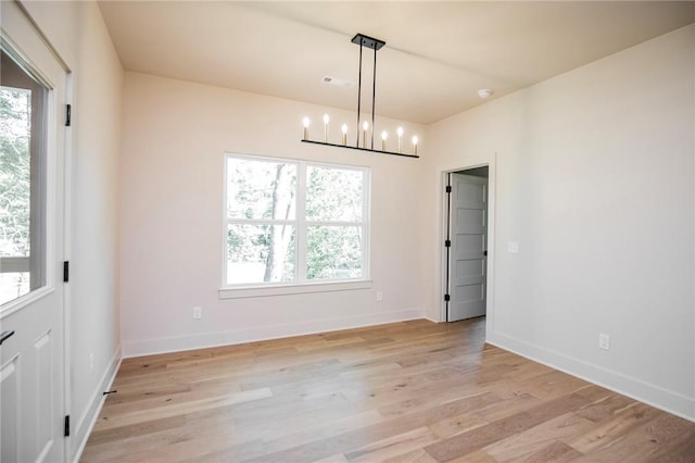 25 Lathrop Dr, Bella Vista, AR 72715 - spare room with a chandelier, light wood-style flooring, and baseboards