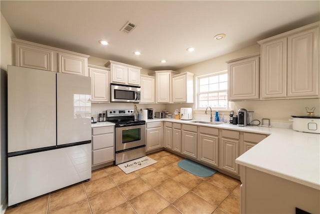 kitchen with stainless steel appliances, a sink, recessed lighting, and light countertops