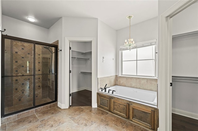6503 S 35th St, Rogers, AR 72758 - full bath featuring a shower stall, a bath, a walk in closet, a chandelier, and baseboards