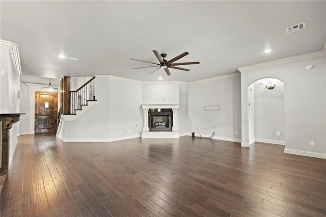 6503 S 35th St, Rogers, AR 72758 - unfurnished living room featuring a glass covered fireplace, ceiling fan, dark wood finished floors, arched walkways, and ornamental molding