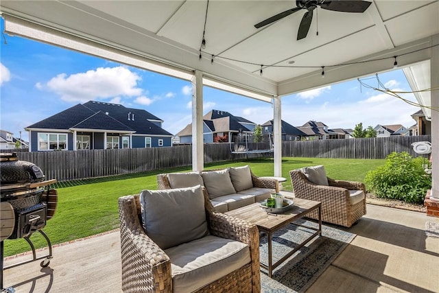 view of patio with a trampoline, outdoor lounge area, a residential view, and a ceiling fan