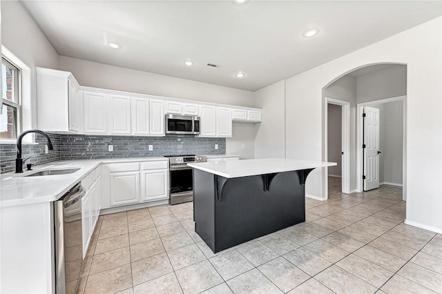 1302 Walker Dr, Rogers, AR 72756 - kitchen with stainless steel appliances, a sink, backsplash, light countertops, and recessed lighting