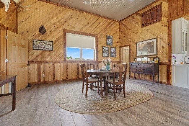 713 Madison Unit 8744, Huntsville, AR 72740 - dining area featuring wood walls, hardwood / wood-style flooring, and vaulted ceiling
