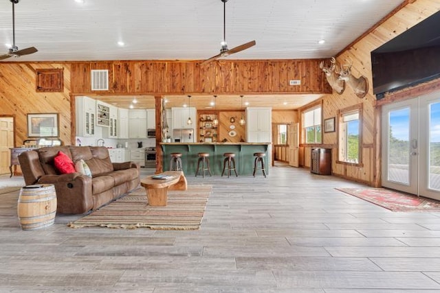 713 Madison Unit 8744, Huntsville, AR 72740 - living room with wood walls, ceiling fan, french doors, light wood-type flooring, and high vaulted ceiling