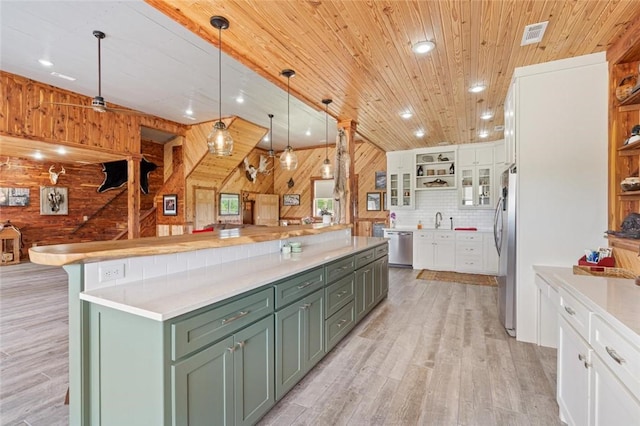713 Madison Unit 8744, Huntsville, AR 72740 - kitchen with green cabinets, white cabinetry, wood walls, appliances with stainless steel finishes, and light wood-type flooring