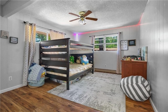 1 Morris Ln, Bella Vista, AR 72715 - bedroom featuring multiple windows, a textured ceiling, wood finished floors, baseboards, and a ceiling fan