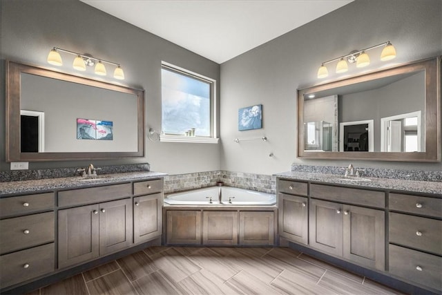 full bathroom featuring two vanities and a bath