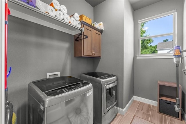 laundry area with cabinet space, washing machine and clothes dryer, and baseboards