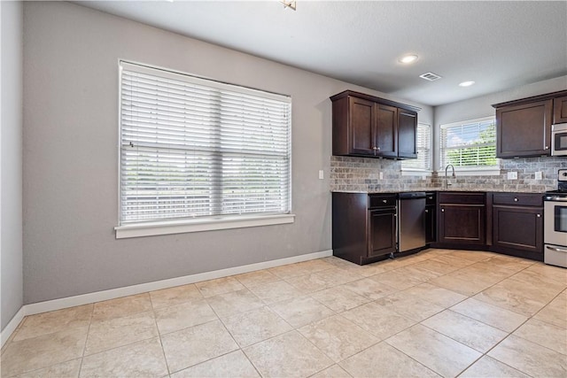 kitchen featuring stainless steel appliances, tasteful backsplash, dark brown cabinetry, a sink, and recessed lighting