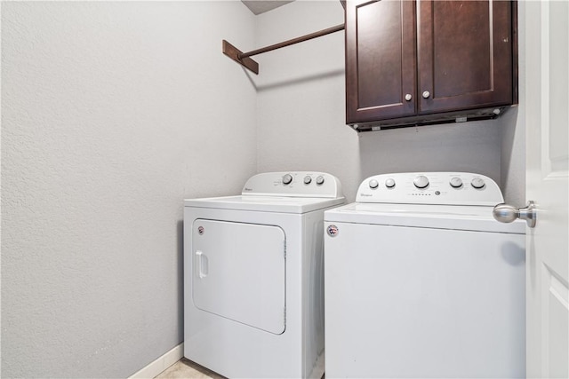 laundry area featuring cabinet space, washer and clothes dryer, and baseboards