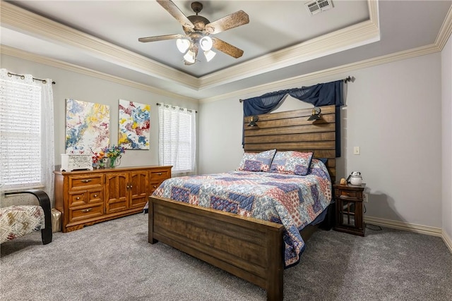 bedroom with carpet flooring, a tray ceiling, ornamental molding, and a ceiling fan