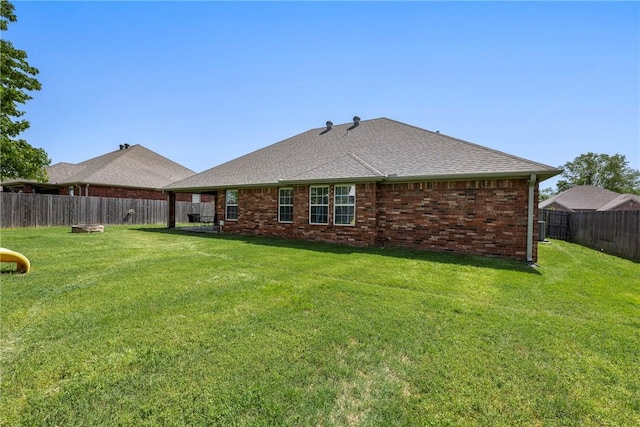 back of property featuring brick siding and a shingled roof