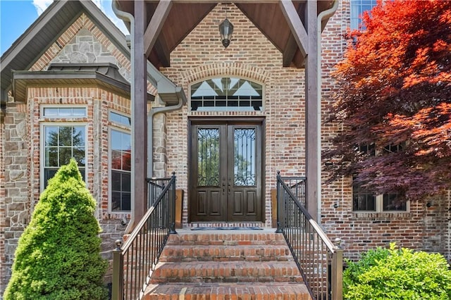 view of exterior entry featuring french doors and brick siding