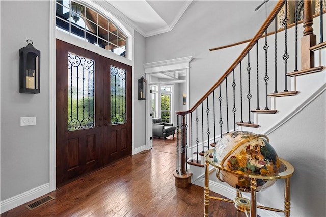 entrance foyer featuring ornamental molding, stairway, baseboards, wood finished floors, and a high ceiling