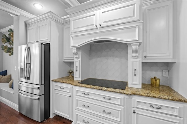 kitchen with stainless steel fridge with ice dispenser, black electric cooktop, white cabinets, decorative backsplash, and light stone countertops
