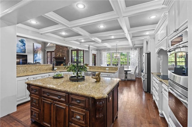 kitchen with a large island, stainless steel appliances, white cabinetry, dark wood-type flooring, and dark brown cabinetry