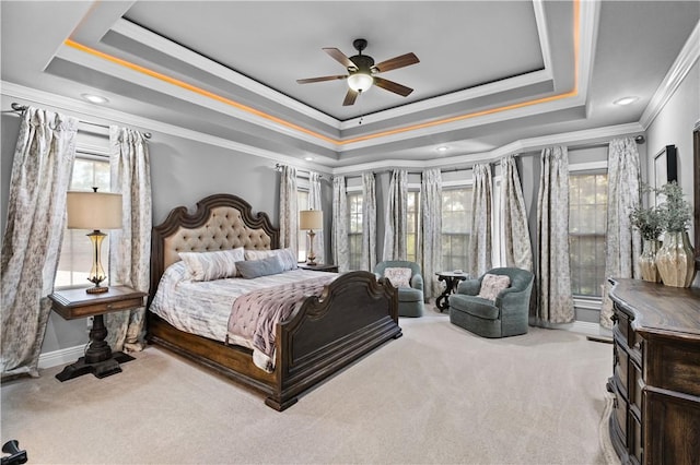 bedroom with a raised ceiling, carpet flooring, crown molding, a ceiling fan, and baseboards