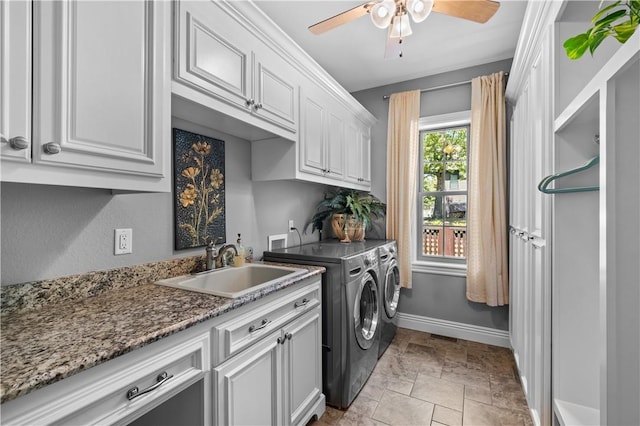 laundry area featuring independent washer and dryer, cabinet space, ceiling fan, baseboards, and light stone finish flooring