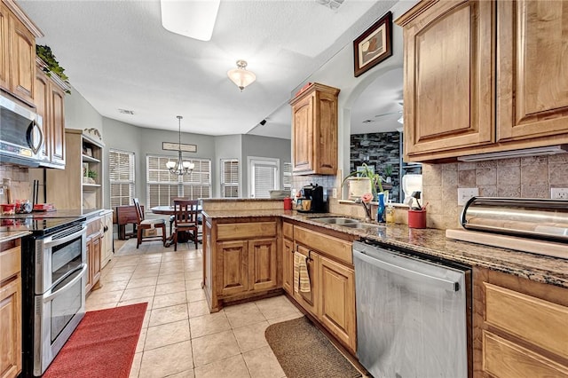 6201 S 36th St, Rogers, AR 72758 - kitchen featuring appliances with stainless steel finishes, backsplash, light tile patterned floors, a sink, and stone counters