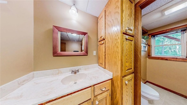 bathroom with toilet, vanity, and tile patterned floors
