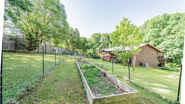 view of yard featuring a garden, a wooden deck, and central air condition unit