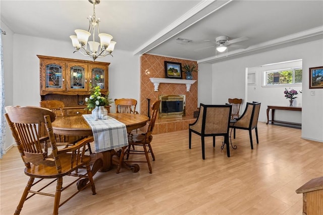 206 Suttle Dr, Springdale, AR 72764 - dining space featuring a chandelier, light wood-style flooring, a ceiling fan, and a tile fireplace