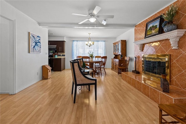 206 Suttle Dr, Springdale, AR 72764 - dining space featuring a tile fireplace, light wood-style floors, a chandelier, and a ceiling fan