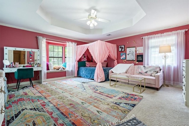 carpeted living area with a tray ceiling, plenty of natural light, ceiling fan, crown molding, and baseboards