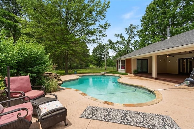swimming pool featuring a patio area, fence, and a ceiling fan