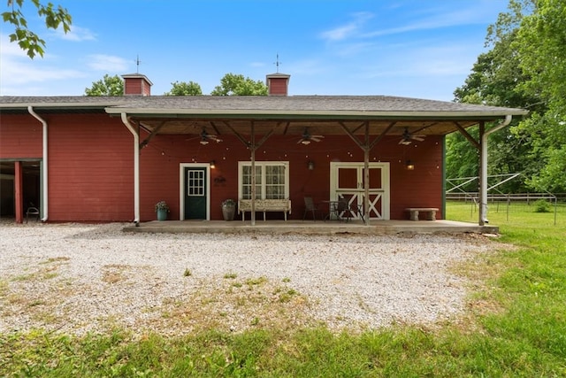 back of house featuring a ceiling fan, a chimney, fence, and a patio area