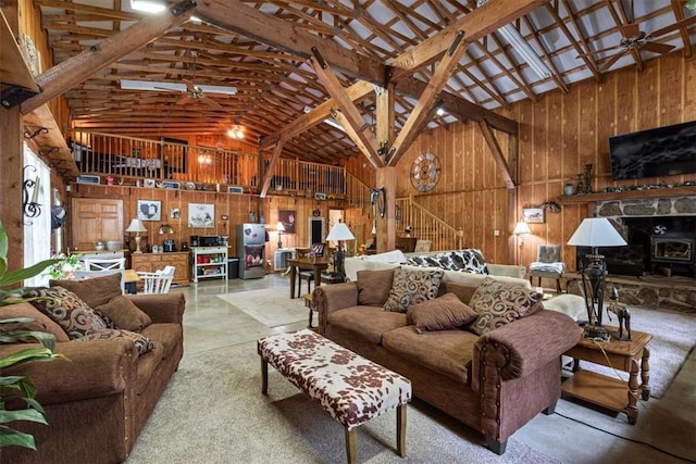 living room featuring ceiling fan, wooden walls, and high vaulted ceiling