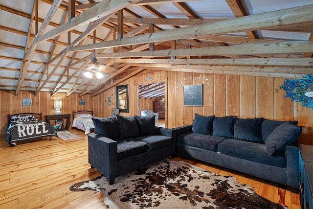 living room featuring vaulted ceiling, wood walls, and hardwood / wood-style floors