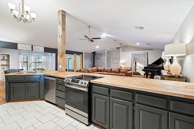 kitchen with butcher block counters, stainless steel appliances, open floor plan, ceiling fan, and lofted ceiling