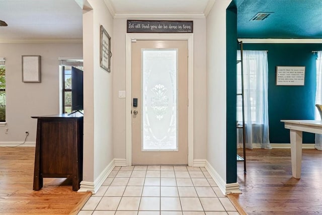 entryway featuring crown molding, wood finished floors, and baseboards