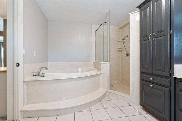bathroom with tile patterned flooring, a shower stall, and a garden tub