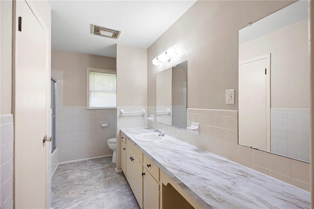 208 Date St, Russellville, AR 72802 - bathroom with toilet, tile walls, vanity, a wainscoted wall, and bathing tub / shower combination